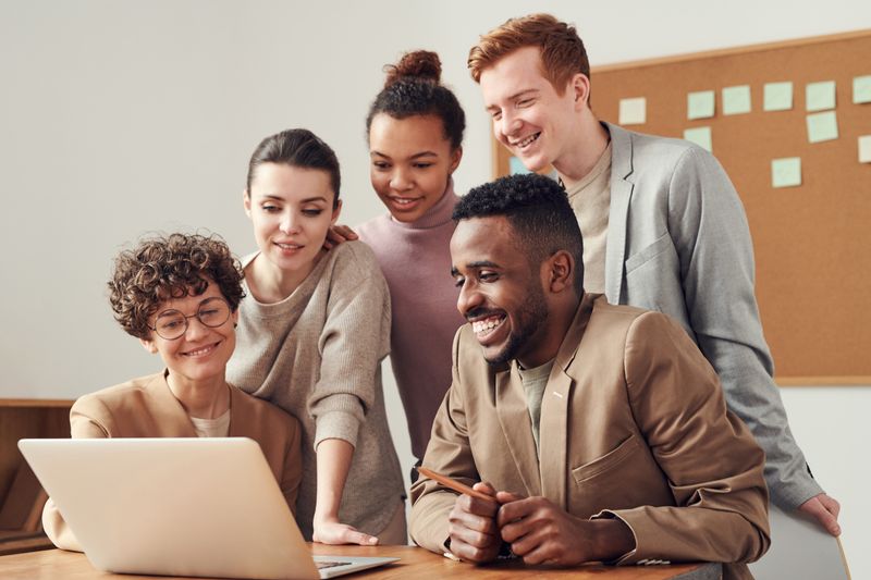 A technology team collaborating around a laptop during a project session